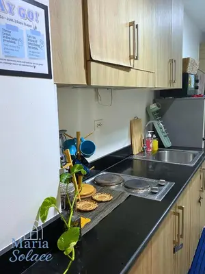 a kitchen counter with a stove with cookies on it at Maria Solace in Manila