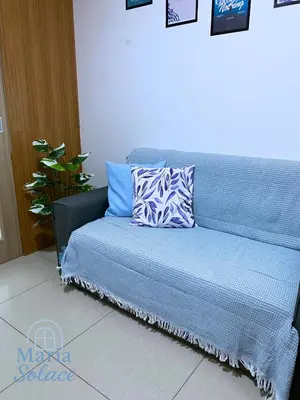 a blue couch with two pillows on top of it at Maria Solace in Manila