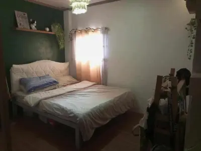 a small bed in a room with a window at Vacation Home by Rowena Sacarez in Trece Martires