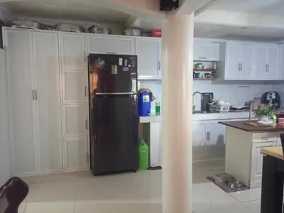 a black refrigerator in a kitchen with white cabinets at Vacation Home by Rowena Sacarez in Trece Martires