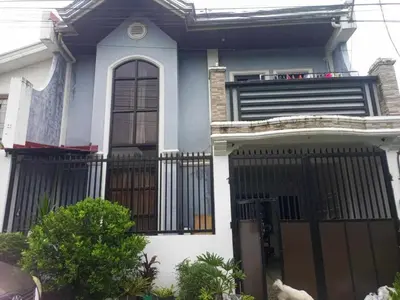 a blue and white house with a black gate at Vacation Home by Rowena Sacarez in Trece Martires