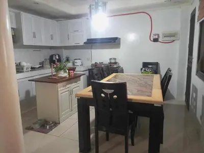 a small kitchen with a wooden table and chairs at Vacation Home by Rowena Sacarez in Trece Martires