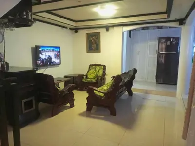 a living room with chairs and a flat screen tv at Vacation Home by Rowena Sacarez in Trece Martires