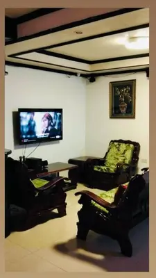 a living room with chairs and a flat screen tv at Vacation Home by Rowena Sacarez in Trece Martires