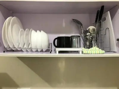a shelf with plates and utensils on it at 1 BR Taytay HIVE Condo WIFI Netflix Pool Patio in Taytay