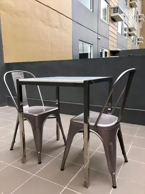 two chairs and a table and a table and chairs at 1 BR Taytay HIVE Condo WIFI Netflix Pool Patio in Taytay