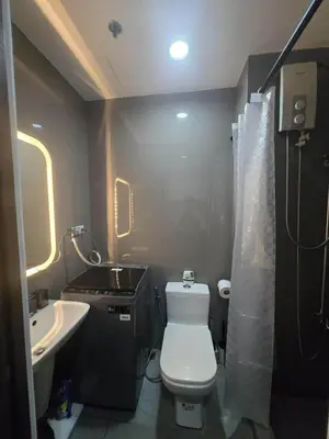 a small bathroom with a toilet and a sink at The Air Residences Makati in Manila