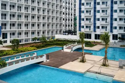 an overhead view of a swimming pool in front of a building at 1 BR Makati JAZZ Condo WIFI Netflix Pool Balcony in Manila