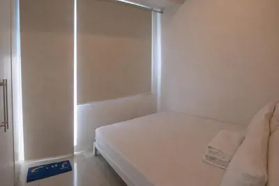 a small bedroom with a bed and a shower at 1 BR Makati JAZZ Condo WIFI Netflix Pool Balcony in Manila