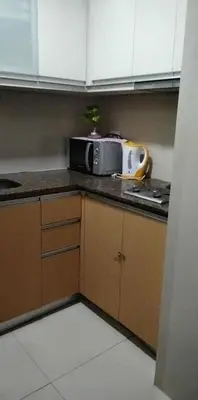 a kitchen with a microwave on a counter at 81 Newport Boulevard across NAIA T3 Airport in Manila