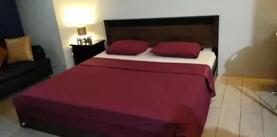 a bedroom with a large bed with two red pillows at 81 Newport Boulevard across NAIA T3 Airport in Manila