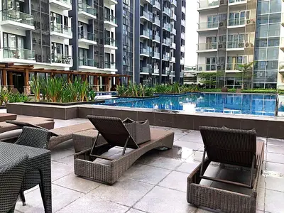 a patio with chairs and a pool in a building at 81 Newport Boulevard across NAIA T3 Airport in Manila