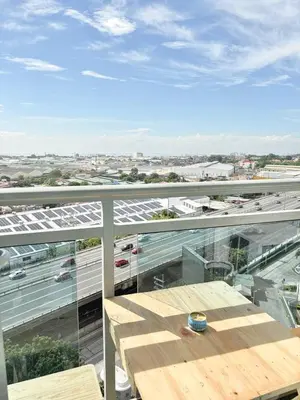 a balcony with a table and a view of a highway at Playa Delea Minimalist Azure 1BR Pool Beach Staycation in Manila