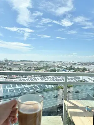 a person holding a glass of beer on a balcony at Playa Delea Minimalist Azure 1BR Pool Beach Staycation in Manila