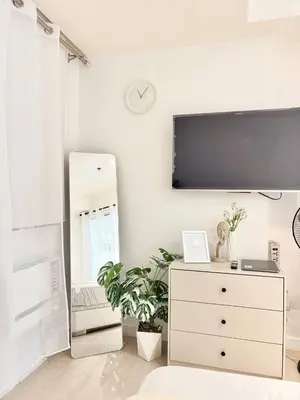 a room with a dresser with a tv on the wall at Playa Delea Minimalist Azure 1BR Pool Beach Staycation in Manila