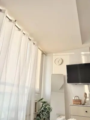 a room with a window with curtains and a tv at Playa Delea Minimalist Azure 1BR Pool Beach Staycation in Manila