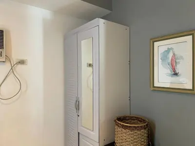 a white cabinet in a room with a basket at Premiere Haven MOA Staycation in Manila