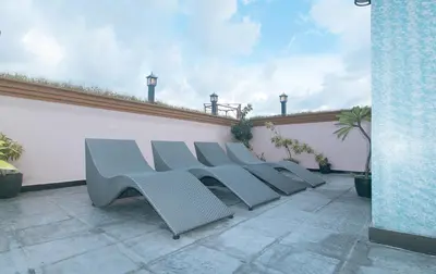 a row of white chairs sitting on a patio at Urban Travellers Hotel by RedDoorz in Manila
