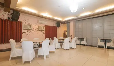 a conference room with white chairs and a table at Urban Travellers Hotel by RedDoorz in Manila