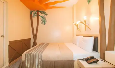 a bedroom with a bed and a phone on a table at Urban Travellers Hotel by RedDoorz in Manila