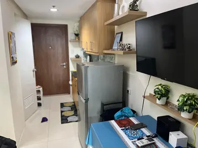 a kitchen with a refrigerator and a table in a room at MOA Staycation Condotel PASAY in Manila