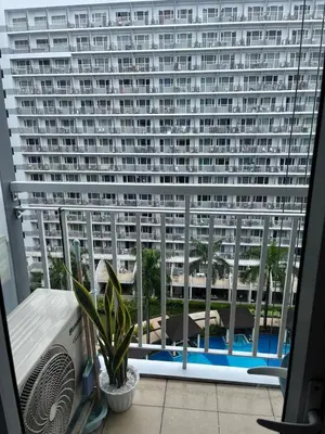a view of a large building from a window at MOA Staycation Condotel PASAY in Manila