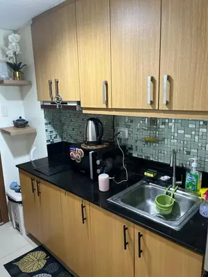 a kitchen with a sink and a microwave at MOA Staycation Condotel PASAY in Manila