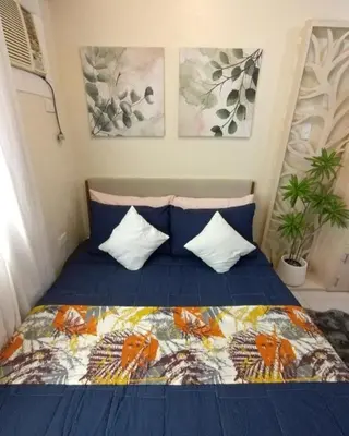 a bedroom with a bed with a blue comforter and pillows at 25mins from NAIA1 in Manila