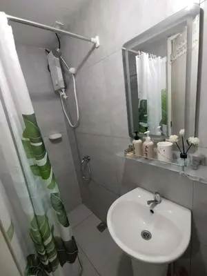 a white bathroom with a sink and a shower at 25mins from NAIA1 in Manila