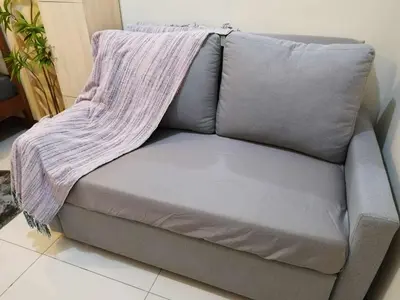 a grey couch with a blanket on top of it at 25mins from NAIA1 in Manila