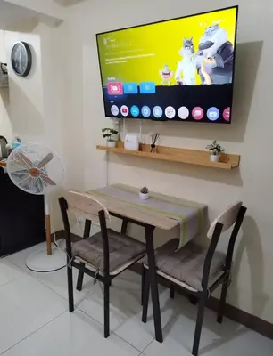 a table and chairs with a television on a wall at 25mins from NAIA1 in Manila