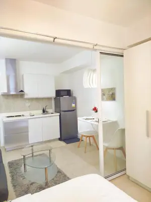 a kitchen with a glass table and a kitchen with a dining room at Azure Staycation with Pool View, Wifi and Netflix in Manila