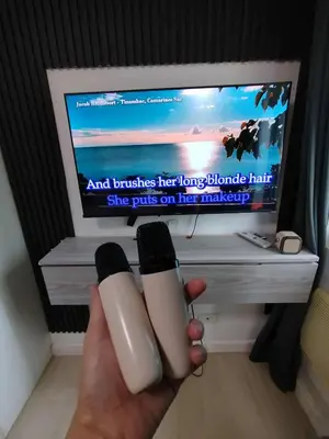 a person holding two nail polish in front of a tv at Azure Staycation with Pool View, Wifi and Netflix in Manila