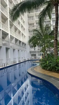 a hotel with a swimming pool in front of a building at HJ Haven in Manila