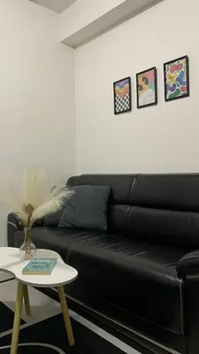 a black leather couch in a living room with a table at HJ Haven in Manila