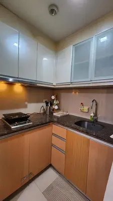 a kitchen with wooden cabinets and a sink and a stove at Hauze of B&Y - 81 Newport Blvd across T3 in Manila
