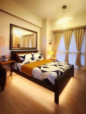a bedroom with a large bed and a mirror at Hauze of B&Y - 81 Newport Blvd across T3 in Manila
