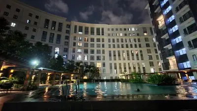 a large building with a pool in front of it at night at Hauze of B&Y - 81 Newport Blvd across T3 in Manila