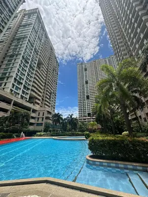 a swimming pool in the middle of tall buildings at Resort-style oasis at the the heart of the city in Manila