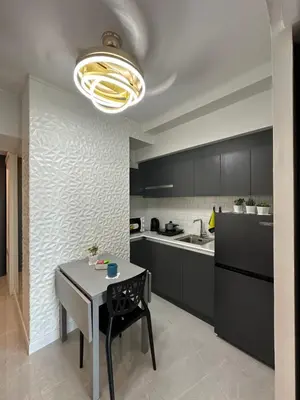 a kitchen with a table and a kitchen with black cabinets at Resort-style oasis at the the heart of the city in Manila