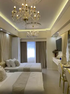 a large bedroom with two beds and a chandelier at Chateau Lumiere Staycation at MOA in Manila
