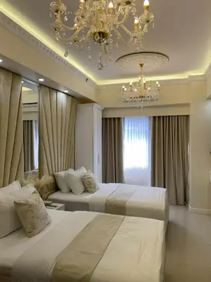 a hotel room with two beds and a chandelier at Chateau Lumiere Staycation at MOA in Manila