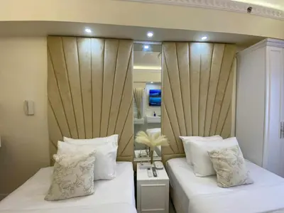 a bedroom with two beds with white pillows at Chateau Lumiere Staycation at MOA in Manila
