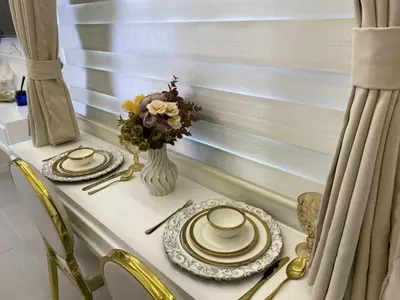 a table with two plates and a vase with flowers at Chateau Lumiere Staycation at MOA in Manila