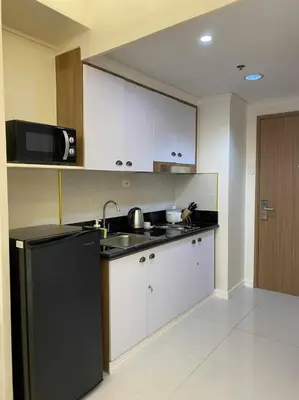 a kitchen with a black refrigerator and a microwave at Chateau Lumiere Staycation at MOA in Manila