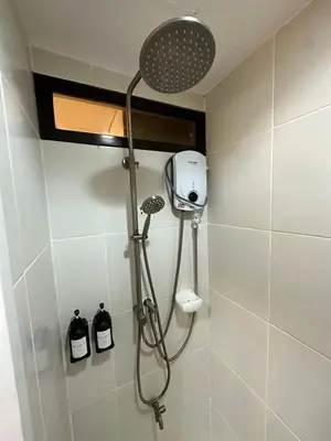 a shower in a bathroom with a shower head at Studio City Staycation in Alabang in Manila