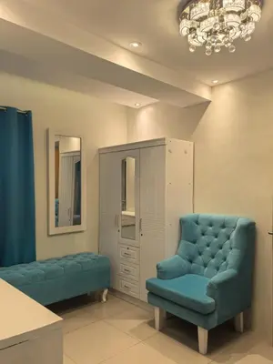 a room with two blue chairs and a cabinet at 2 BEDROOM SHELL RESIDENCES MOA view in Manila