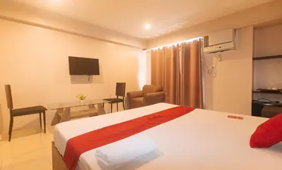 a hotel room with a bed and a table and a desk at RedDoorz at Regina Hometel J Victor in Manila