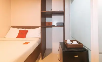 a bedroom with a bed and a book shelf at RedDoorz at Regina Hometel J Victor in Manila