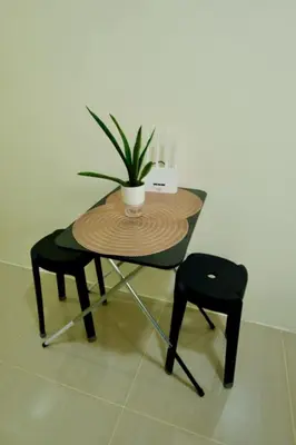 a table with a potted plant and two chairs at Condotel in Manila